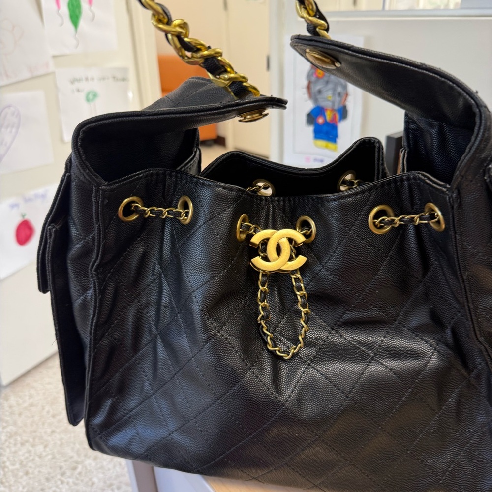Black quilted shoulder bag. Gold accents with gold chain handle.